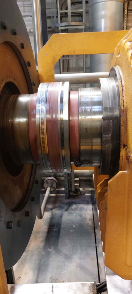 Damaged rotor slip rings showing scoring and surface wear prior to precision onsite machining in power generation facility.